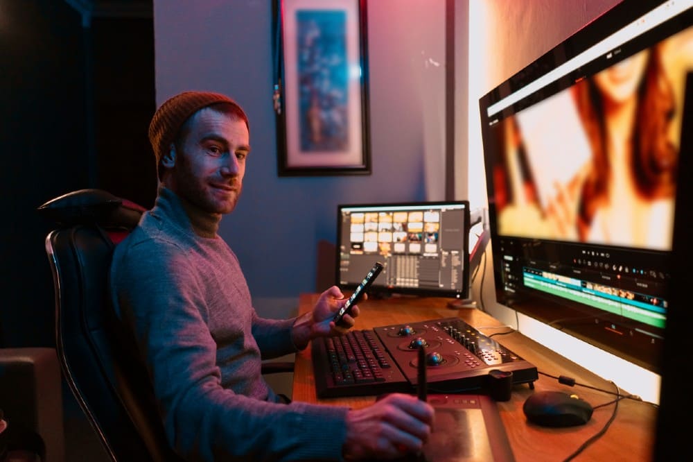 male-video-editor-sitting-at-his-computer-using-ph-2021-09-01-10-46-00-utc